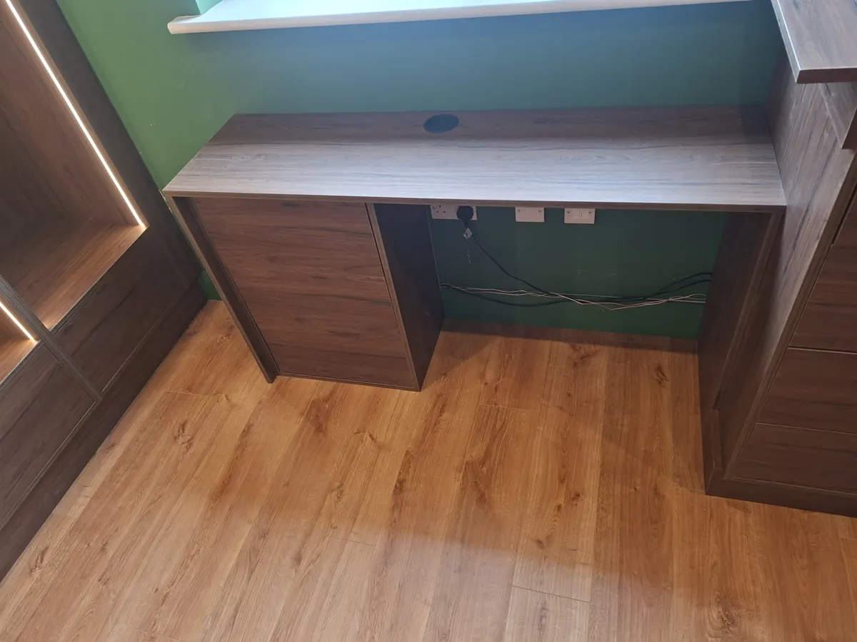 Fitted desk and storage unit with timber-effect finish.