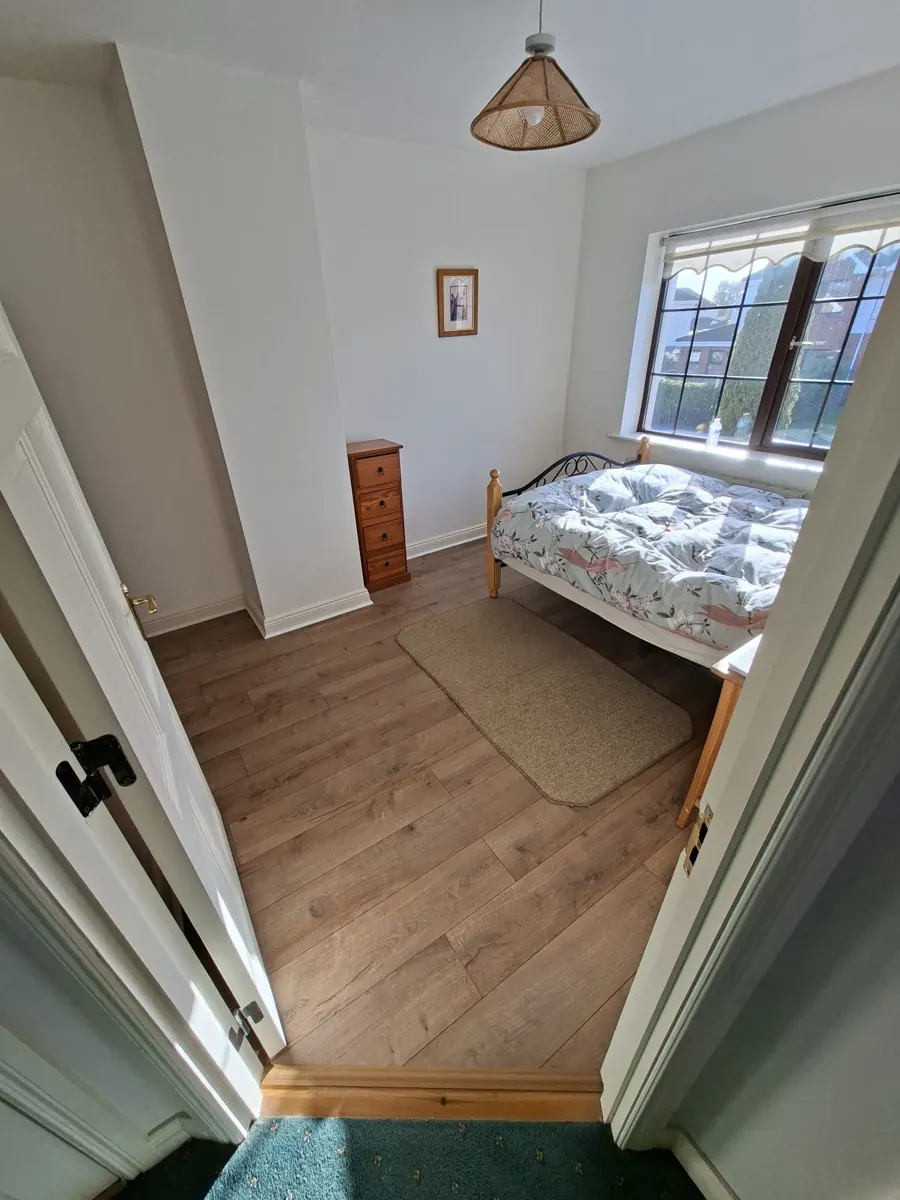 Timber-effect bedroom flooring with threshold detail.