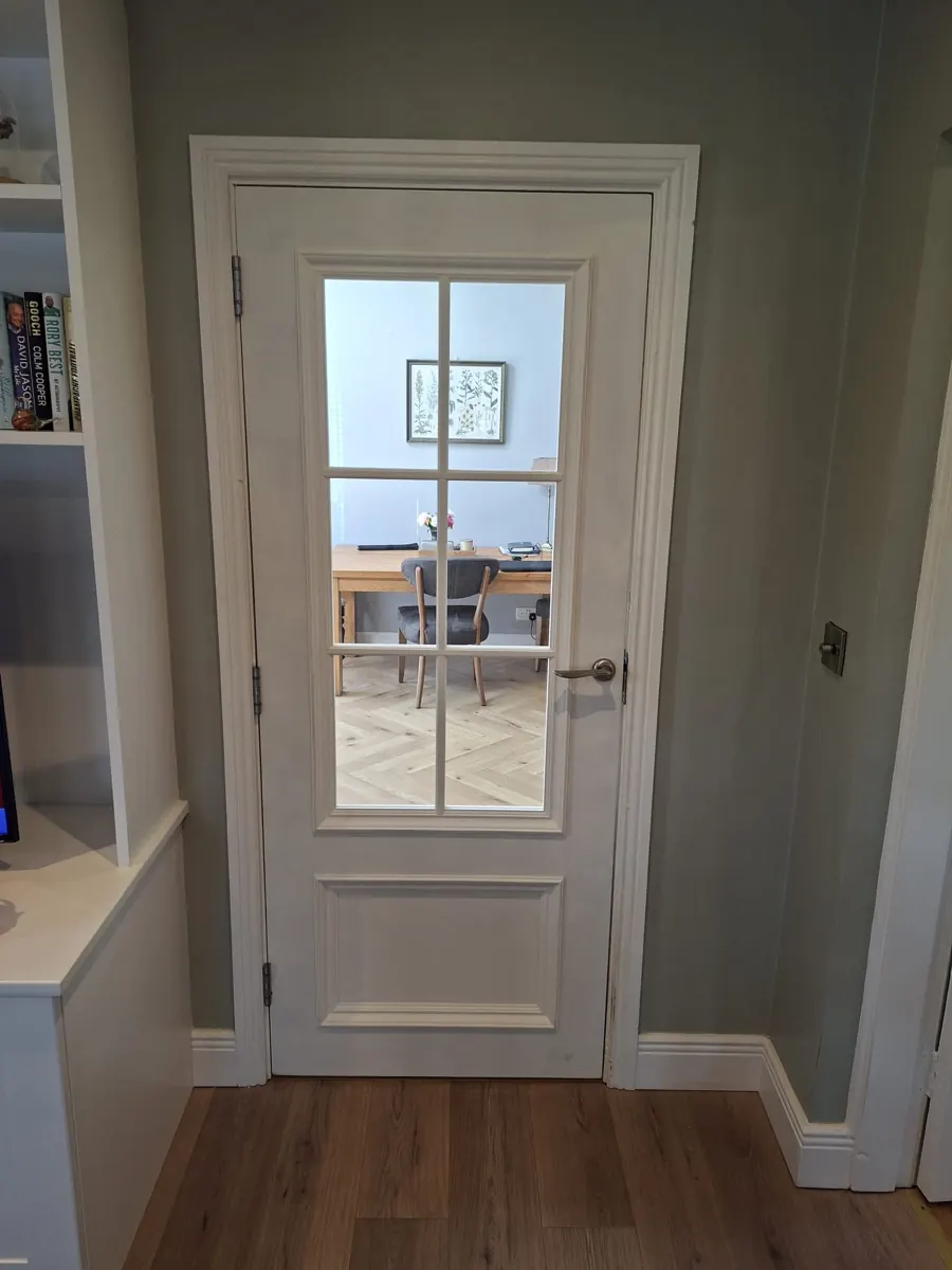 Glazed interior door with fitted architrave leading to a home office.