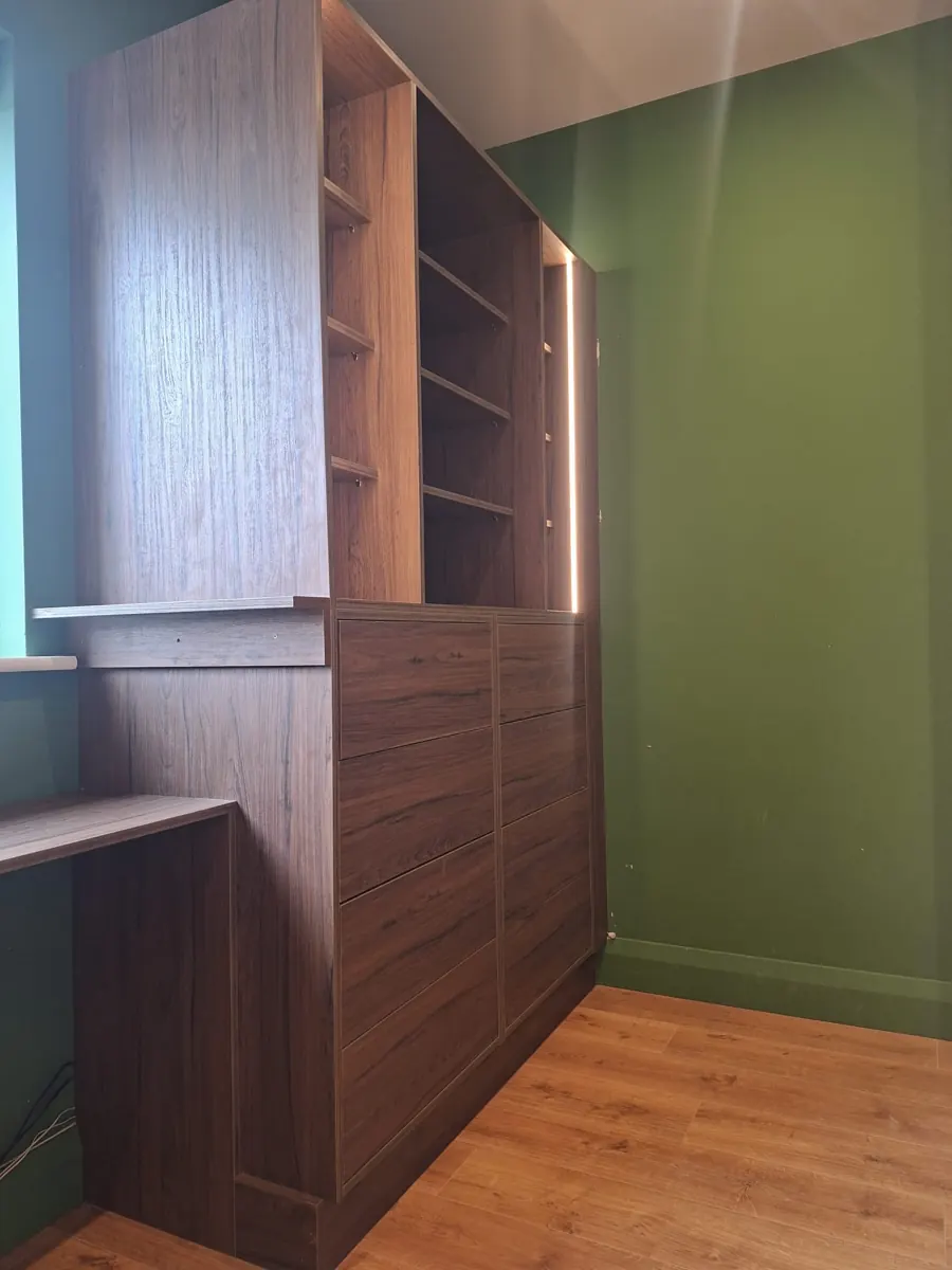 Fitted home office storage and shelving in a green room.