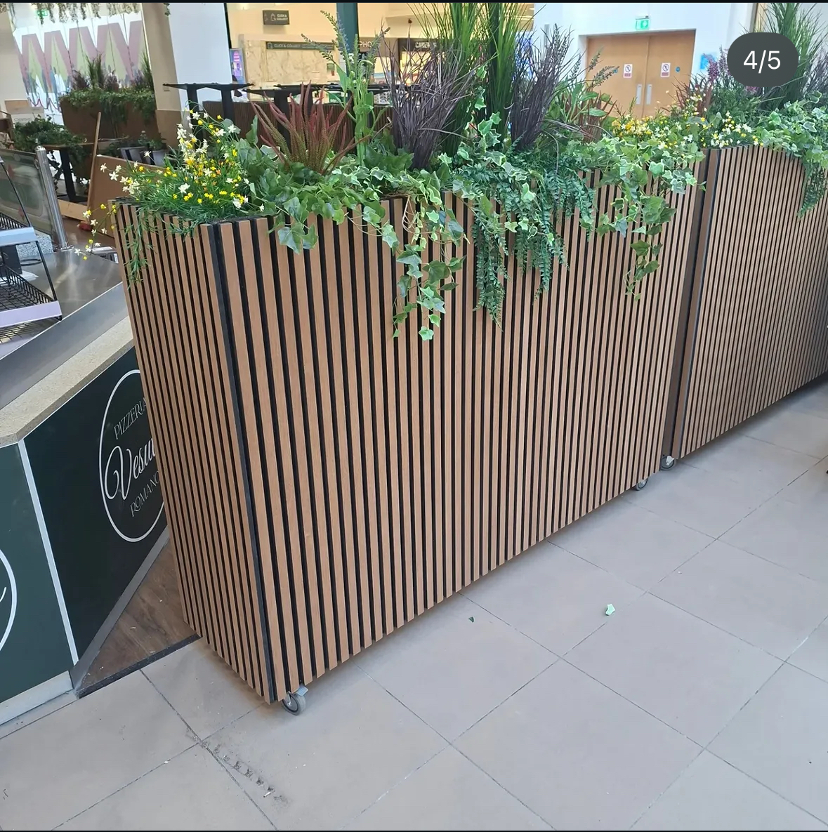 Commercial slatted timber planter with integrated greenery.